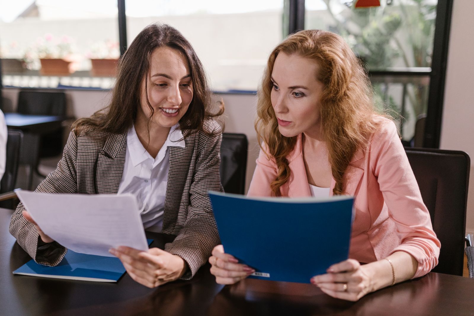 Two women at a table reviewing paperwork together